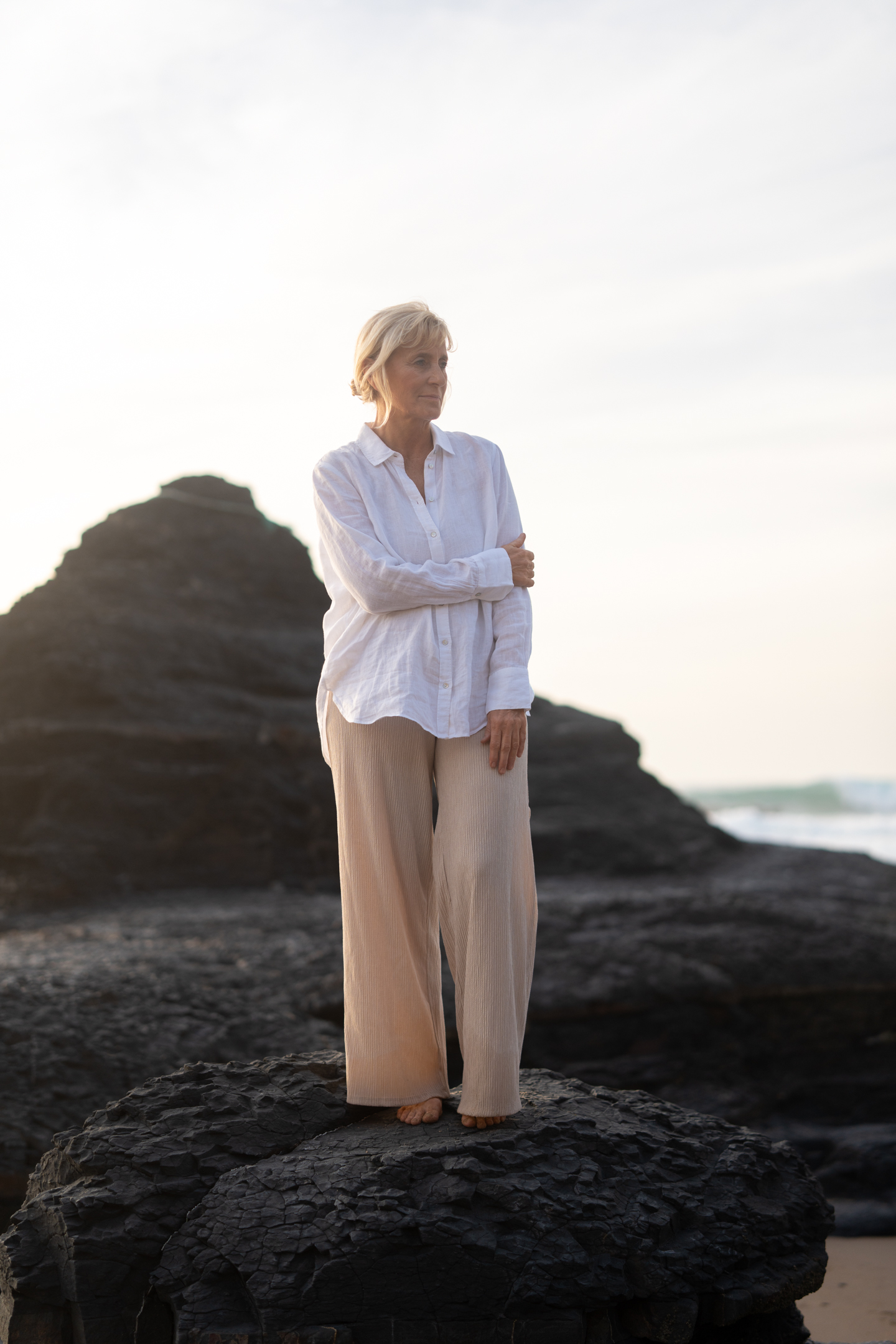 Professional branding photo Portugal – confident woman standing on rocks by the ocean