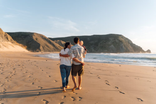 Family walking together along an Algarve beach at golden hour