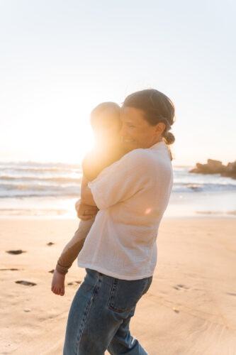 Mother hugging her baby in golden sunset light during an Algarve family photoshoot