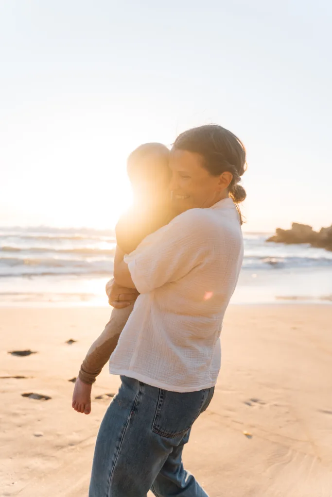 Mother hugging her baby in golden sunset light during an Algarve family photoshoot